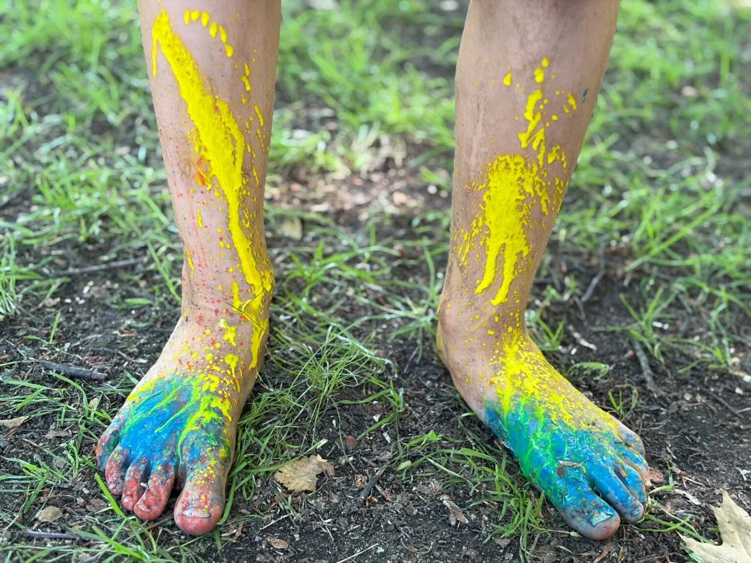 Bunt bemalte Kinderfüße im Garten